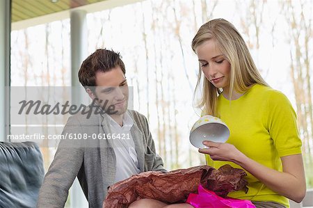 Femme heureuse en regardant un cadeau donné par son petit ami