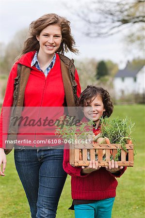 Mother and son with a crate of homegrown vegetables