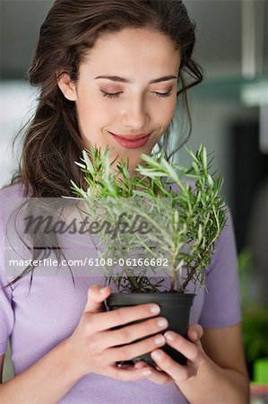 Woman smelling a rosemary plant