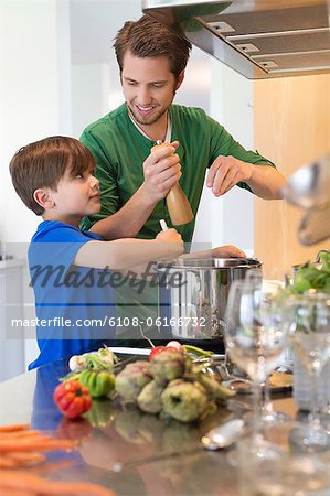 Boy assisting his father in the kitchen