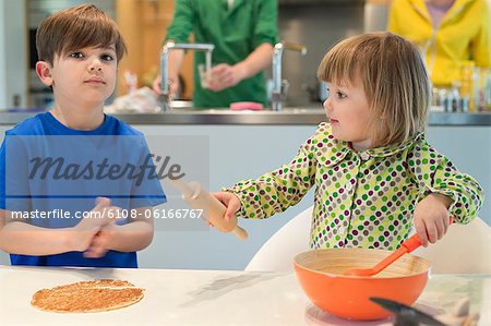 Enfants avec leurs parents dans le fond de cuisson dans la cuisine
