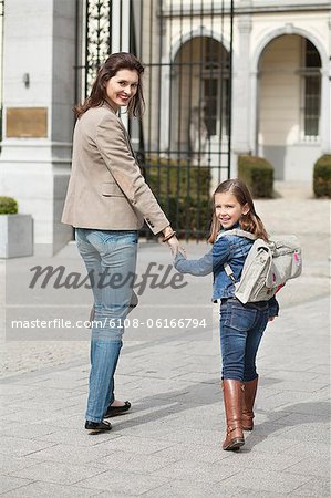 Girl with her mother walking to school
