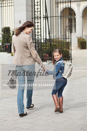 Fille avec sa mère à pied à l'école
