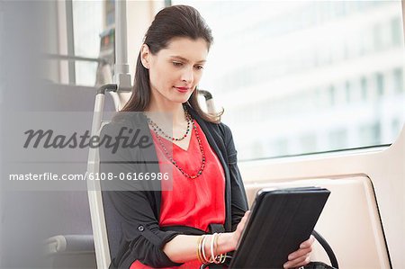 Femme voyageant dans un bus à l'aide d'une tablette numérique