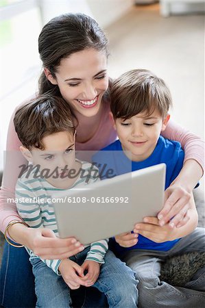 Femme montrant une tablette numérique à leurs enfants