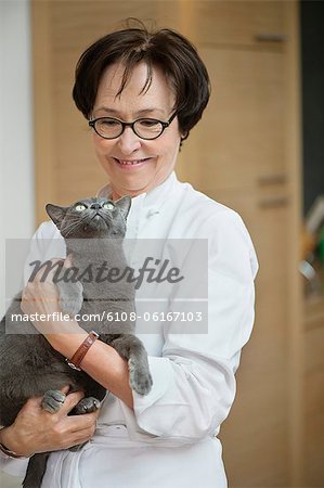 Femme tenant un chat et souriant