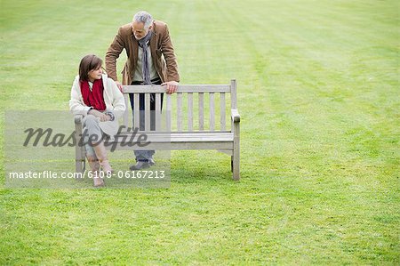 Homme assis avec sa fille sur un banc dans un parc