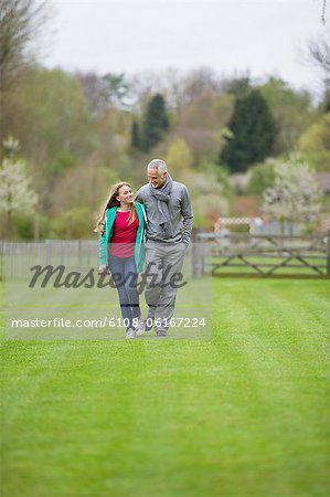 Homme qui marche avec sa fille dans un champ
