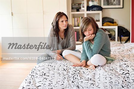 Woman scolding her daughter in the bedroom