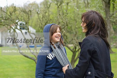 Woman with her daughter having fun in an orchard