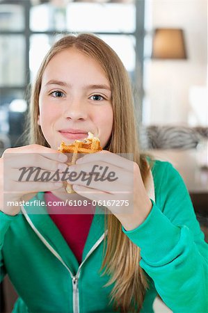 Portrait d'une jeune fille mangeant gaufre