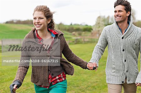 Couple holding hands in a field