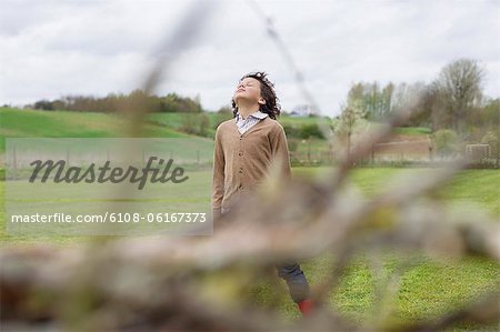 Boy daydreaming in a field