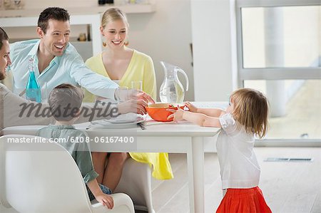 Little girl serving fruit bowl on dining table