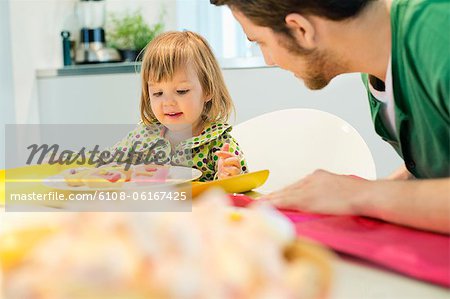Mann und Tochter am Frühstückstisch