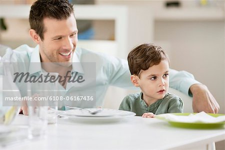 Mann mit seinem Sohn sitzen am Esstisch