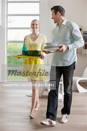 Couple carrying food and plates for serving