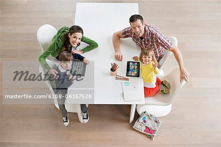 High angle view of couple with their children at study table