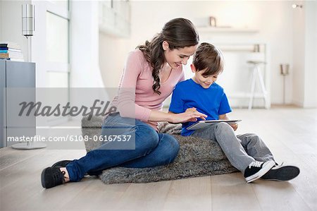 Woman looking at her son using a digital tablet