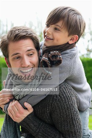 Happy Boy Reiten huckepack auf seinen Vater