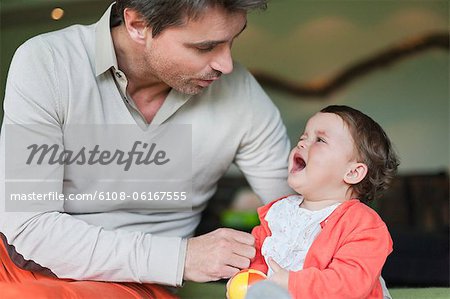 Man consoling his crying daughter