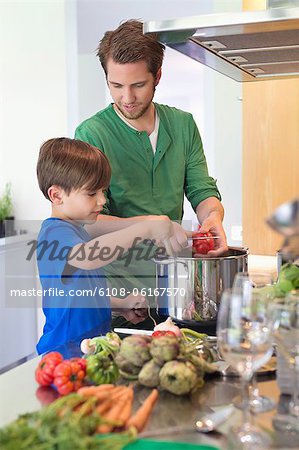 Boy assisting his father in the kitchen