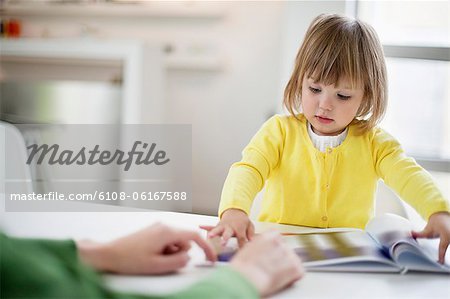 Woman teaching her daughter at home Woman teaching her daughter at home
