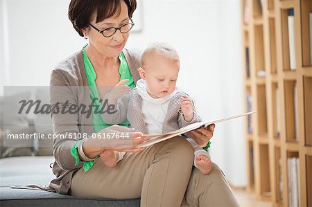 Femme avec sa petite-fille, lisant un livre de photo