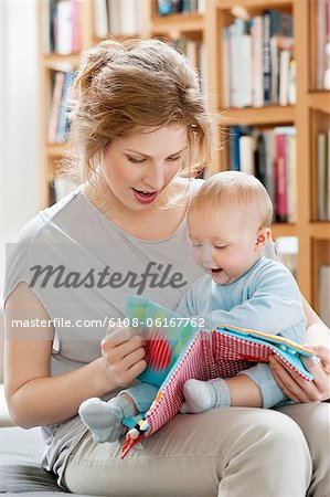 Femme montrant un livre photo à sa fille