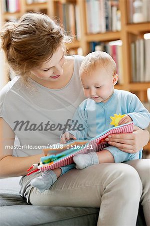 Femme montrant un livre photo à sa fille