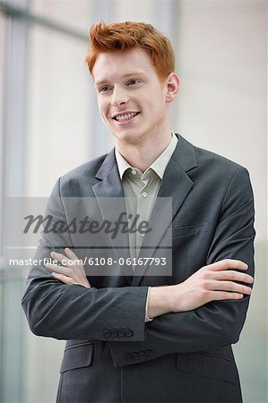 Close-up of a businessman smiling with his arms crossed in an office