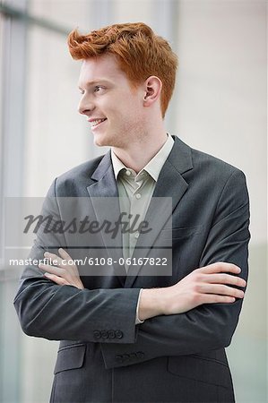 Close-up of a businessman smiling with his arms crossed in an office