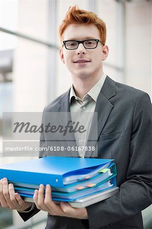Portrait of a businessman holding files in an office