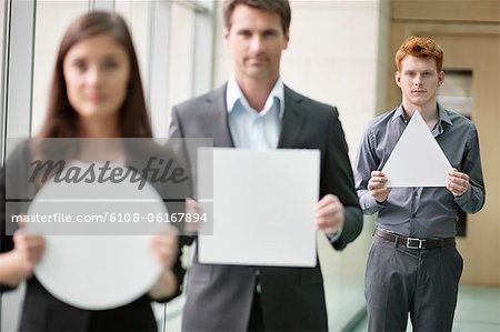 Geschäftsleute halten geometrische Form Plakate in einem Büro