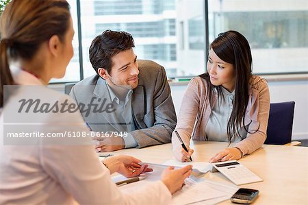 Couple signing documents with real estate agent Couple signing documents with real estate agent