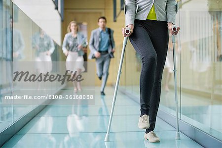 Disabled woman walking with a man and a woman running behind her