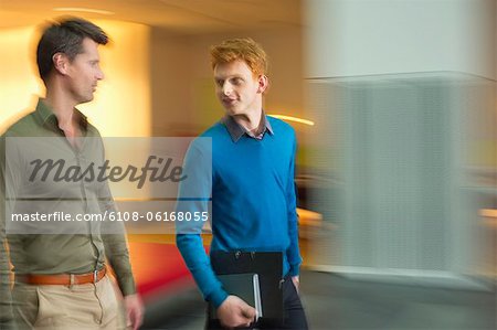 Businessmen discussing in an office corridor