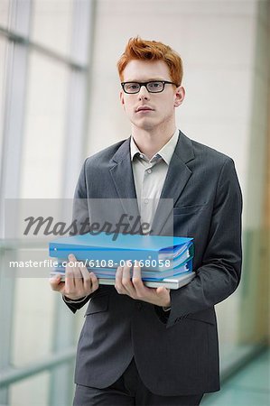 Portrait of a businessman holding files in an office