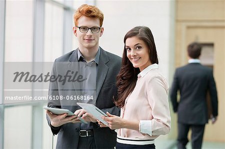 Portrait of business executives using digital tablets in an office