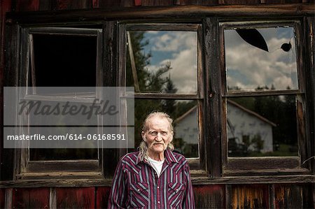 Senior man outside shack, portrait Senior man outside shack, portrait