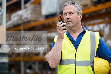 Homme sur talkie walkie en entrepôt