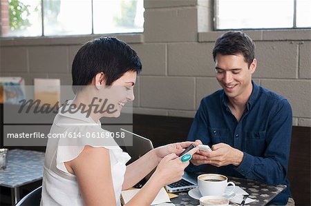 Businesspeople using smartphones in cafe