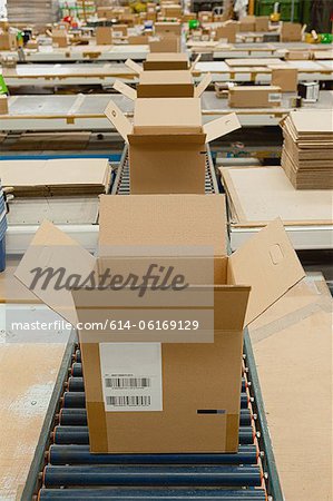 Open cardboard boxes on conveyor belt