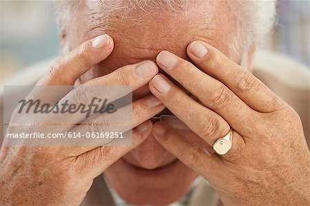 Senior man with head in hands, close up portrait