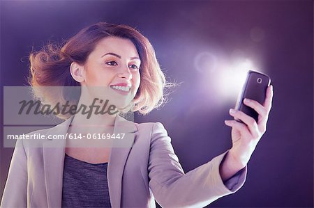 Jeune femme regardant téléphone portable avec lumières