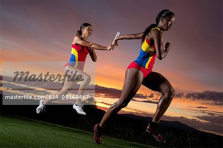 Coureurs de relais féminin en passant le bâton