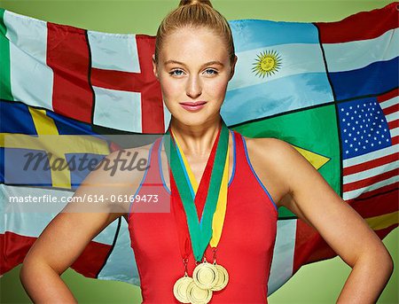 Young woman in front of international flags wearing medals