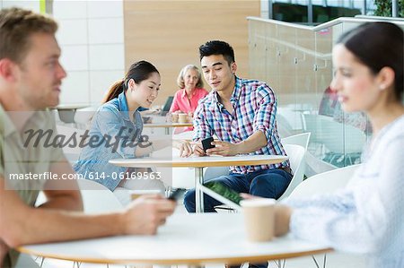 Junges Paar im Bereich Kantine, Blick auf Handy