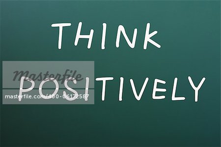 Think positively written with white chalk on a blackboard background