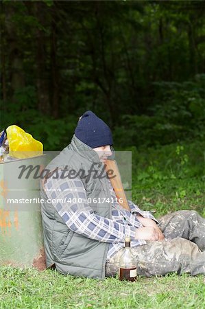 Homeless leaning against the garbage bins